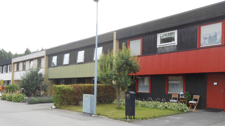 En väg med radhus i rött, grönt och vitt
